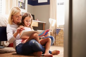 positive parenting with mother reading book to daughter