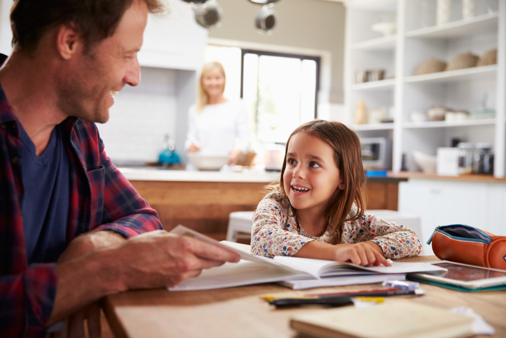 parent teaching kid in the kitchen table